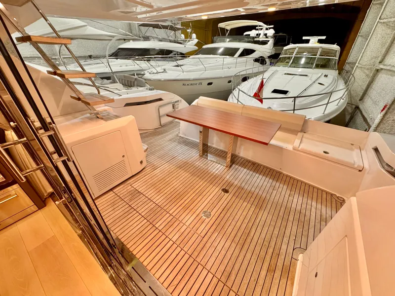 Slide: The Image of 2022 Ferretti Yachts 550 interior with wooden deck and seating area in a marina. - 77