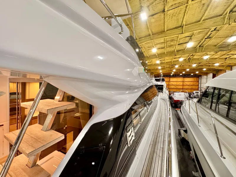 Slide: The Image of 2022 Ferretti Yachts 550 in a well-lit indoor showroom, showcasing sleek design and craftsmanship. - 82