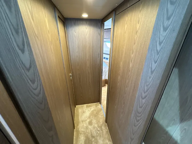 Slide: The Image of Interior hallway of 2022 Ferretti Yachts 550, featuring wood paneling and carpet flooring. - 21