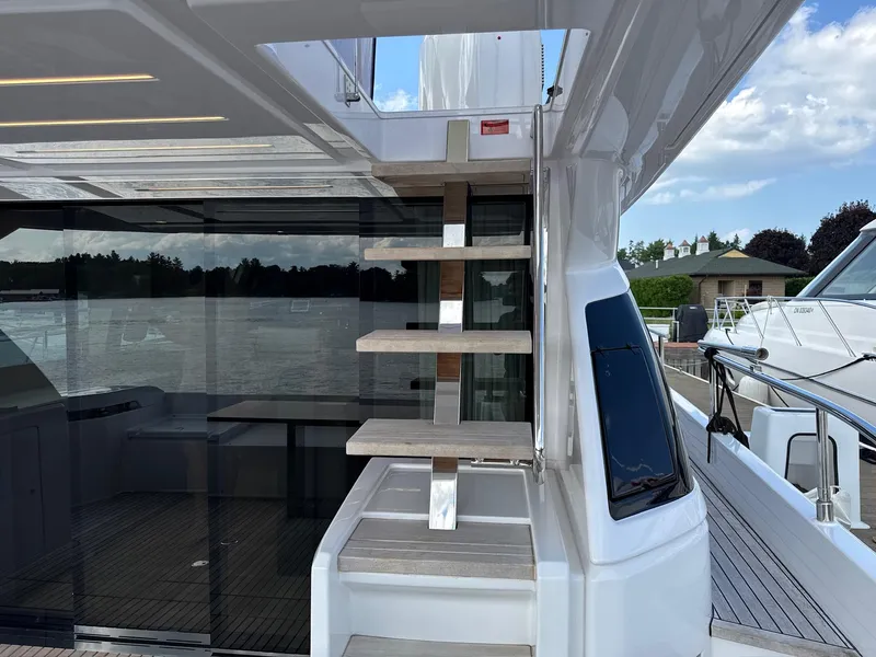 Slide: The Image of 2022 Ferretti Yachts 550, modern staircase, sleek design, docked by the water. - 25