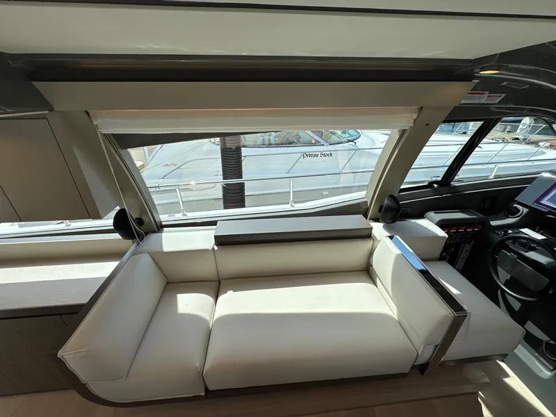 Slide: The Image of Interior of 2022 Ferretti Yachts 550, featuring a sleek white sofa and modern design elements. - 6