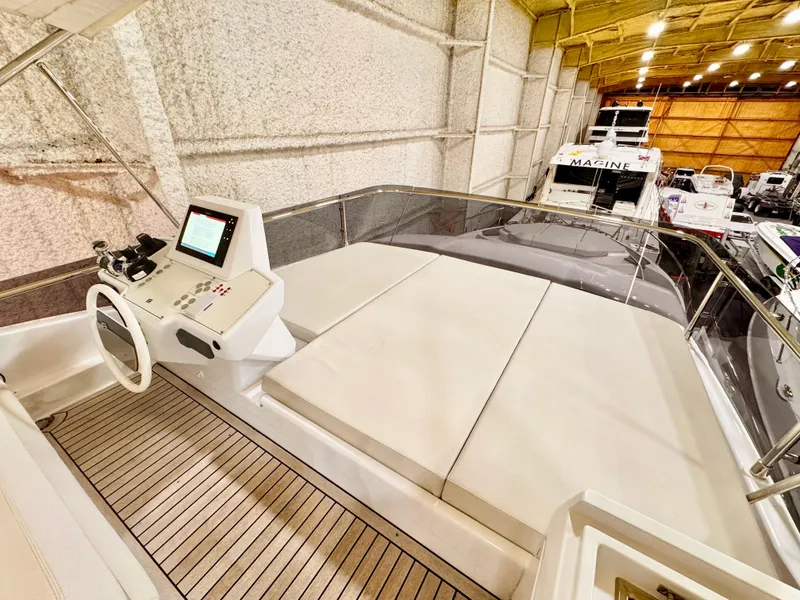 Slide: The Image of 2022 Ferretti Yachts 550 interior with helm station and spacious seating in a well-lit showroom. - 66