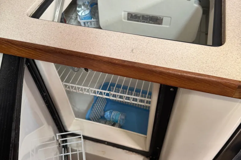 Slide: The Image of Refrigerator interior of 2001 Catalina 42 MK II sailboat, featuring storage shelves and cooling unit. - 25