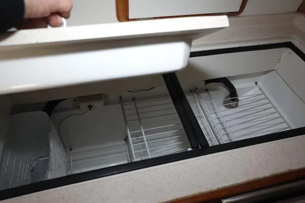 Slide: The Image of Open storage compartments in a 2000 Catalina 320 boat galley. - 10