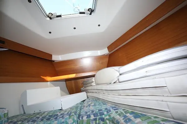 Slide: The Image of Cozy cabin interior of 2000 Catalina 320 sailboat with bedding and wooden paneling. - 19