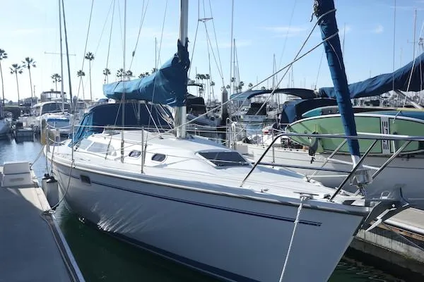 Slide: The Image of 2000 Catalina 320 sailboat docked in marina with blue covers and clear sky. - 2
