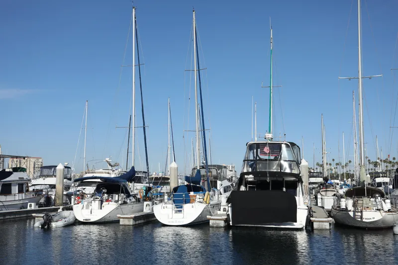 Slide: The Image of Sailboats docked at marina, featuring a 2000 Catalina 320 under clear blue sky. - 21