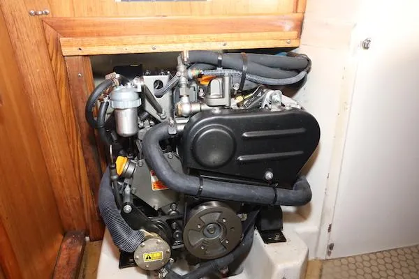 Slide: The Image of Engine compartment of a 2000 Catalina 320 sailboat, showcasing mechanical components and hoses. - 22