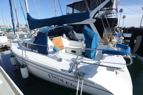 Slide: The Image of Catalina 320 sailboat, 2000 model, docked in a marina with blue covers and clear skies. - 3