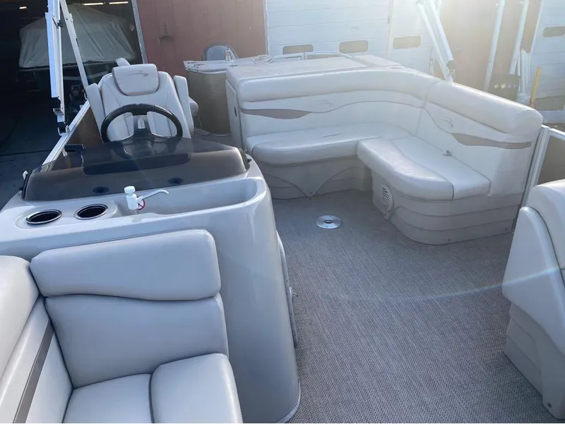 Slide: The Image of 2016 Bennington 22 SSX Elliptical Toon Package interior with beige seating and steering console. - 11