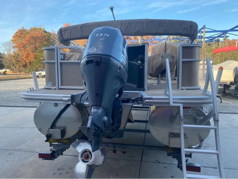 Slide: The Image of 2016 Bennington 22 SSX Elliptical Toon Package with outboard motor, docked outdoors. - 7