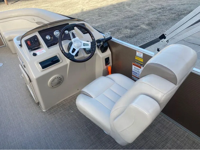 Slide: The Image of 2016 Bennington 22 SSX Elliptical Toon Package boat helm with beige captain's chair. - 8