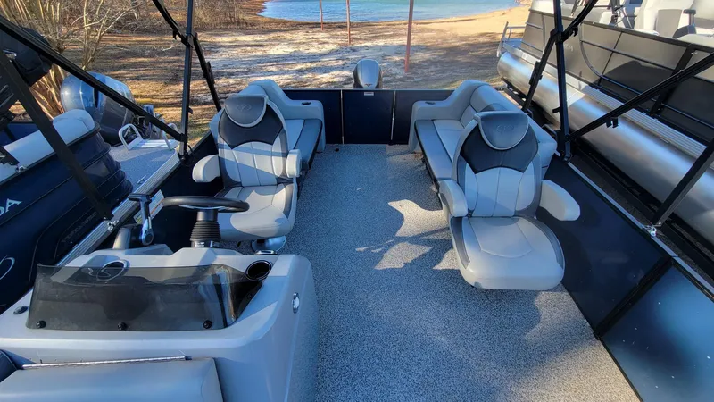 Slide: The Image of 2023 Veranda Vista 20 RC pontoon boat interior with plush seating and steering console. - 7