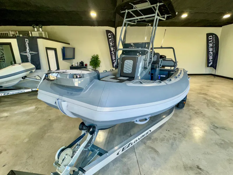 Slide: The Image of 2025 Highfield Sport 560 boat displayed indoors on a trailer. - 1