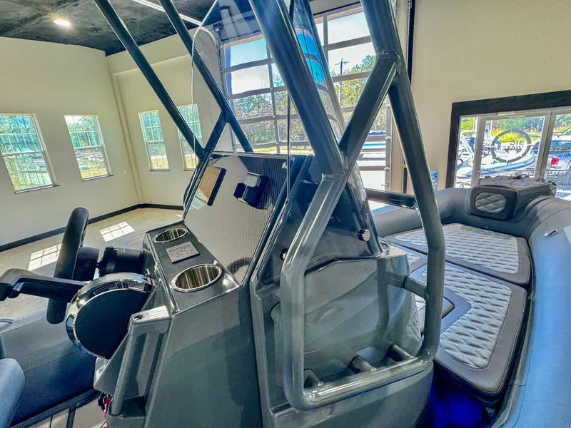 Slide: The Image of 2025 Highfield Sport 560 boat interior with modern console and seating in showroom. - 11
