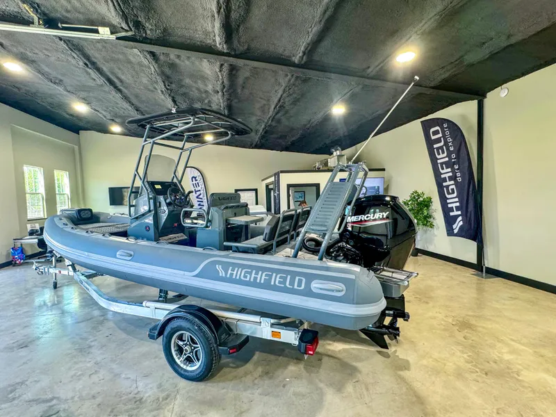 Slide: The Image of 2025 Highfield Sport 560 boat displayed indoors on a trailer. - 2