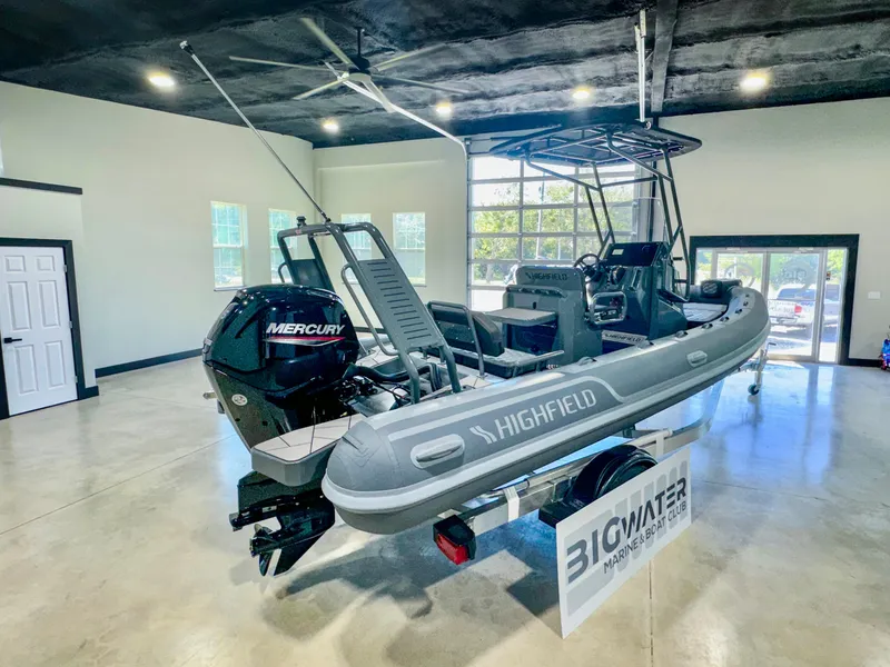 Slide: The Image of 2025 Highfield Sport 560 boat with Mercury engine displayed indoors. - 3