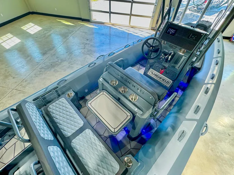 Slide: The Image of 2025 Highfield Sport 560 boat interior with modern seating and control panel in a showroom. - 4