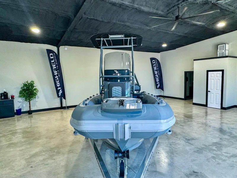 Slide: The Image of 2025 Highfield Sport 560 boat displayed indoors with banners and modern decor. - 5