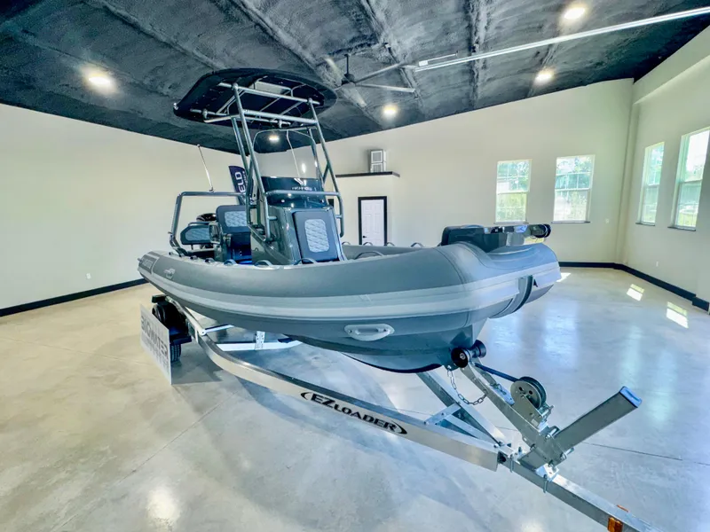 Slide: The Image of 2025 Highfield Sport 560 boat on trailer in spacious indoor showroom. - 9