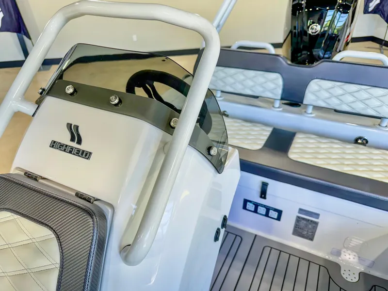 Slide: The Image of 2025 Highfield Sport 460 boat interior with steering console and cushioned seating. - 12
