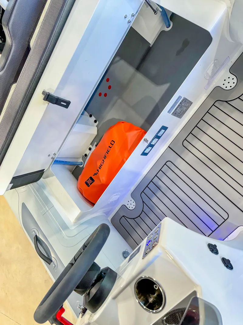 Slide: The Image of 2025 Highfield Sport 460 boat interior with storage compartment and steering wheel. - 9