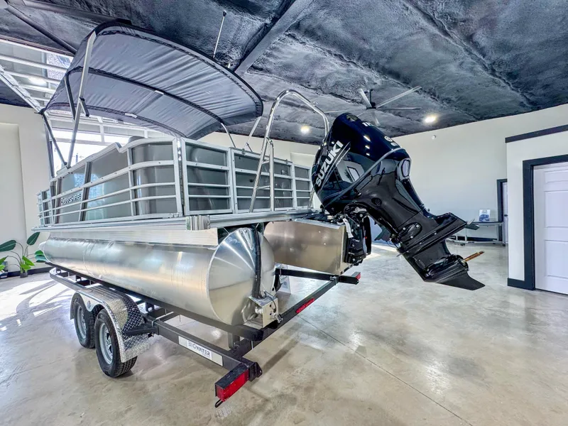 Slide: The Image of 2025 Berkshire 20′ LE pontoon boat with outboard motor on trailer in showroom. - 5