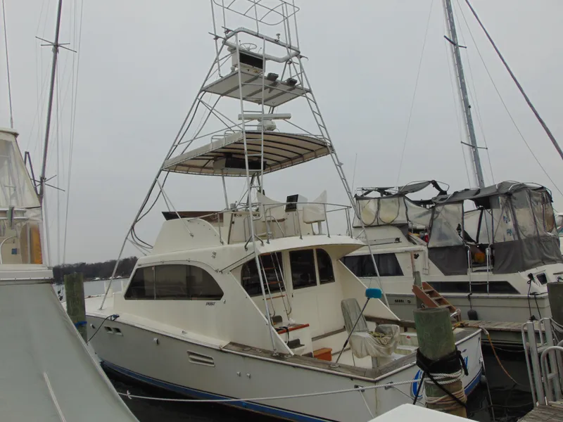 The Image of 1981 Post 46 Sportfish boat docked, featuring a tall tower and spacious deck. - 0