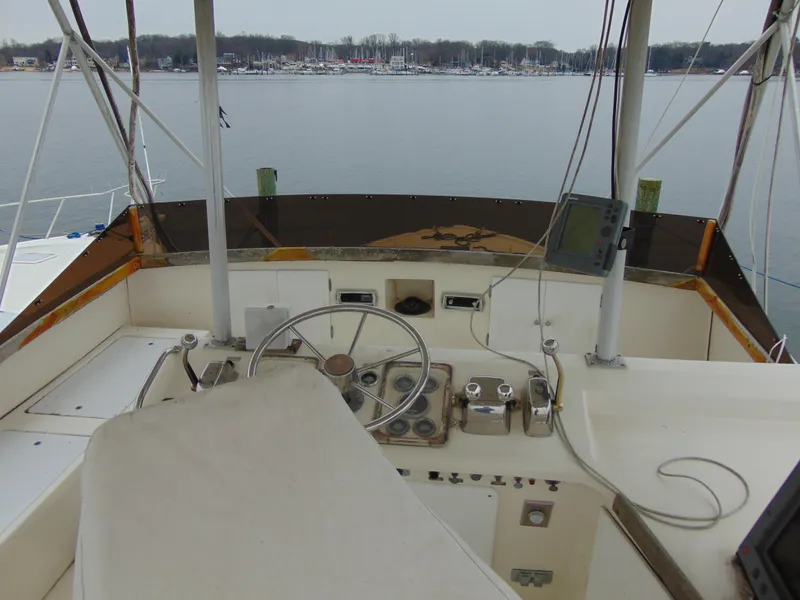 Slide: The Image of 1981 Post 46 Sportfish helm with steering wheel, controls, and water view. - 16
