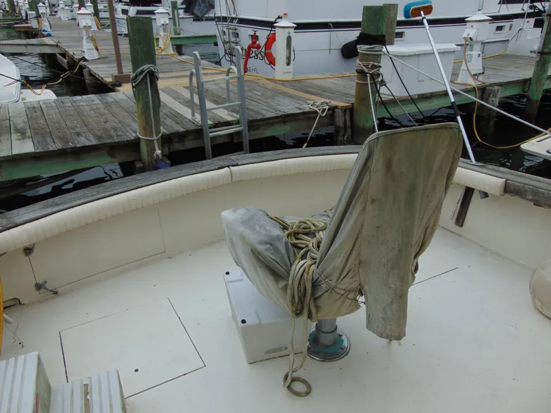 Slide: The Image of 1981 Post 46 Sportfish boat with weathered captain's chair at dock. - 22