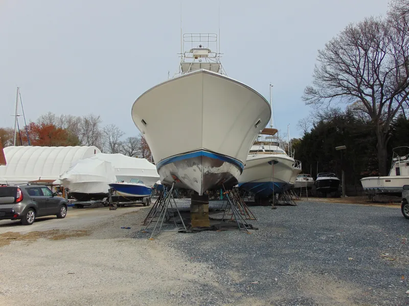 Slide: The Image of 1981 Post 46 Sportfish boat on dry dock, surrounded by other vessels and trees. - 28