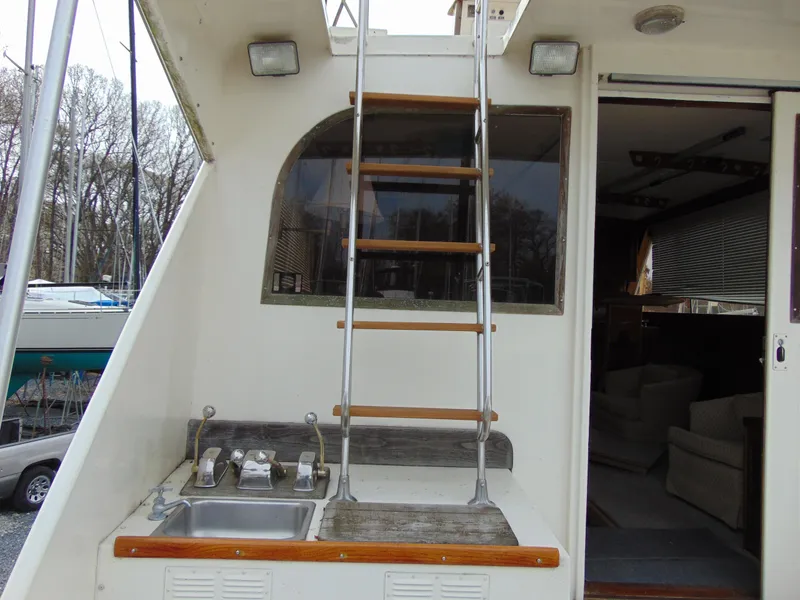 Slide: The Image of 1981 Post 46 Sportfish boat with ladder, outdoor sink, and cabin entrance. - 32