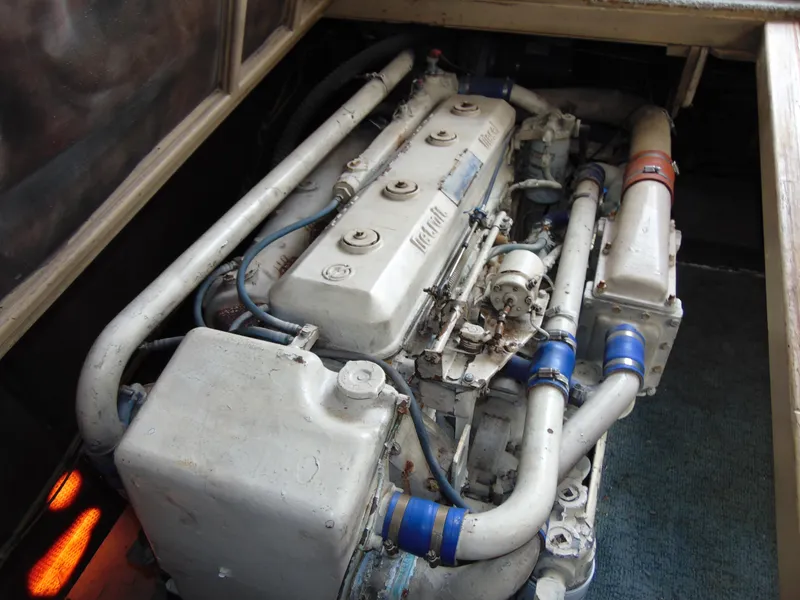 Slide: The Image of Engine compartment of a 1981 Post 46 Sportfish boat, showcasing mechanical components and piping. - 43