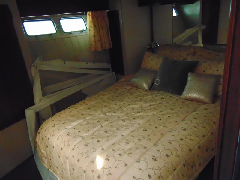 Slide: The Image of Cozy bedroom interior of 1981 Post 46 Sportfish yacht with patterned bedding and pillows. - 49