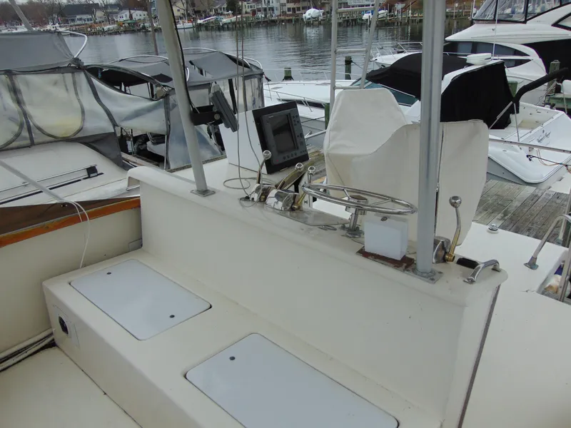 Slide: The Image of 1981 Post 46 Sportfish boat helm with controls and seating, docked at marina. - 15