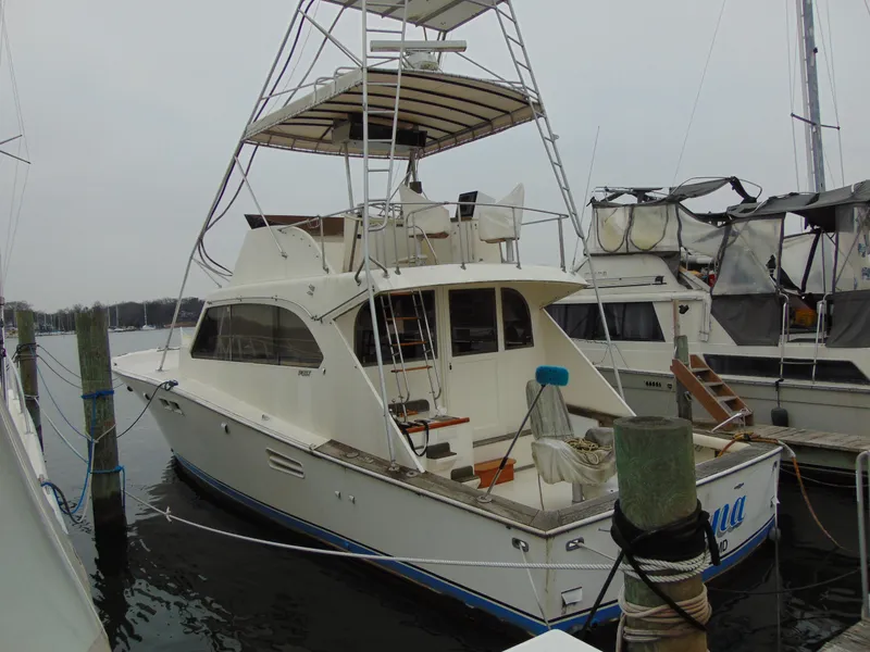 Slide: The Image of 1981 Post 46 Sportfish boat docked, featuring a flybridge and spacious deck. - 2