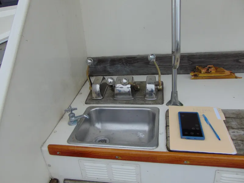 Slide: The Image of 1981 Post 46 Sportfish boat sink area with faucet, tablet, and pen on counter. - 21