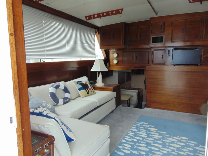 Slide: The Image of 1981 Post 46 Sportfish yacht interior with white sofa, nautical decor, and wooden cabinetry. - 3