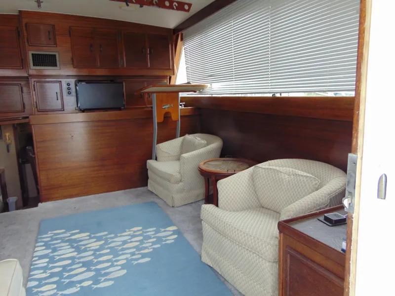 Slide: The Image of 1981 Post 46 Sportfish interior with cozy seating, wooden cabinets, and a nautical-themed rug. - 4