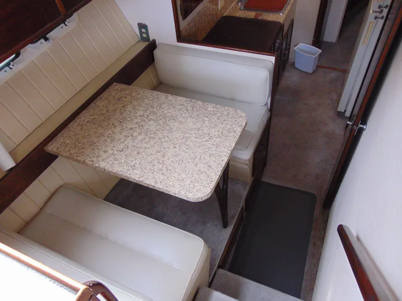 Slide: The Image of 1981 Post 46 Sportfish interior with dining area and white cushioned seating. - 47
