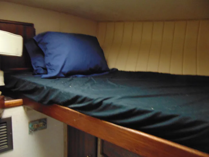 Slide: The Image of 1981 Post 46 Sportfish cabin with a cozy bunk bed and blue bedding. - 7