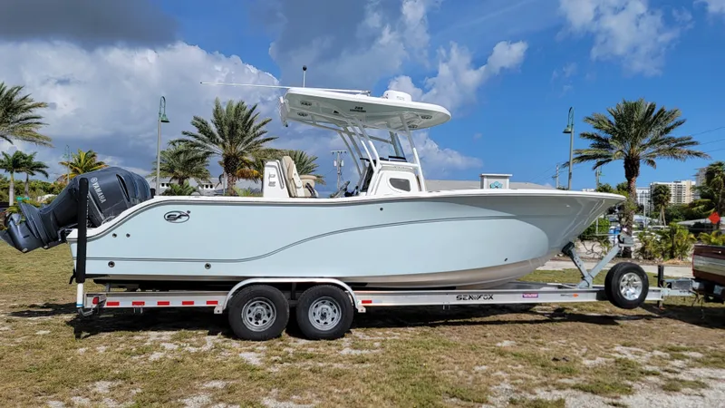 Slide: The Image of 2017 Sea Fox 288 Commander boat on trailer, parked outdoors with palm trees in background. - 10