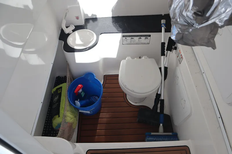 Slide: The Image of 2017 Sea Fox 288 Commander boat bathroom with toilet, sink, and cleaning supplies. - 24