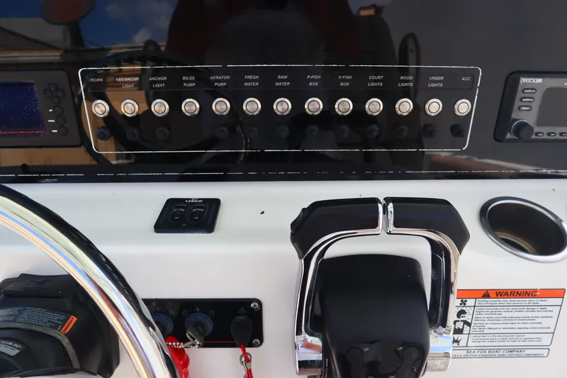 Slide: The Image of Control panel of a 2017 Sea Fox 288 Commander boat with various switches and throttle. - 49