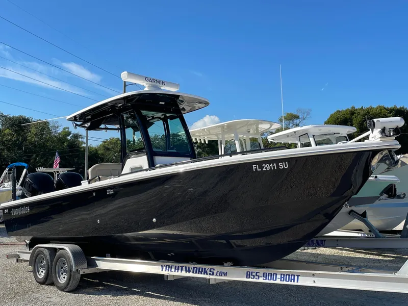 Slide: The Image of 2020 Everglades 273 Center Console boat on trailer, black hull, clear sky background. - 18