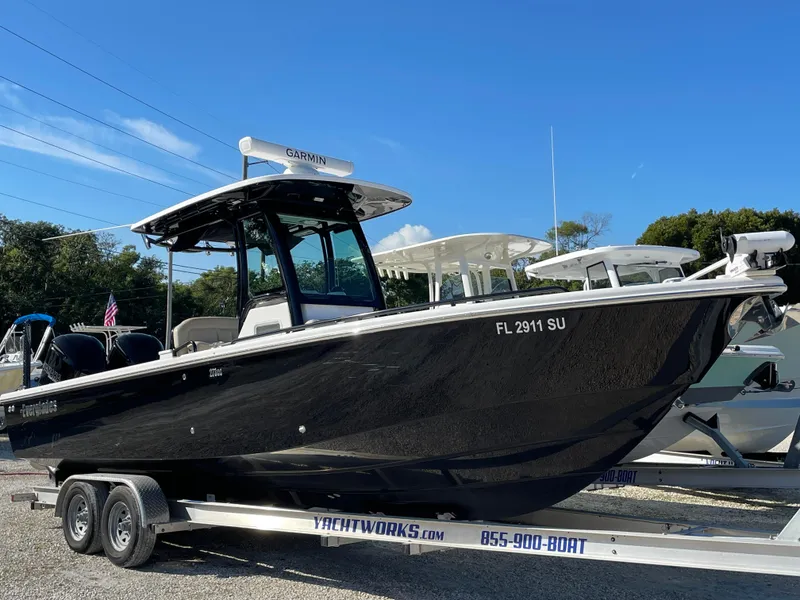 Slide: The Image of 2020 Everglades 273 Center Console boat on trailer, black hull, parked outdoors. - 19