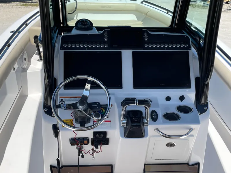 Slide: The Image of 2020 Everglades 273 Center Console boat dashboard with dual screens and steering wheel. - 23
