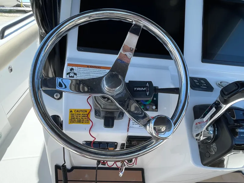 Slide: The Image of Steering wheel of 2020 Everglades 273 Center Console boat, featuring control panel and throttle. - 24