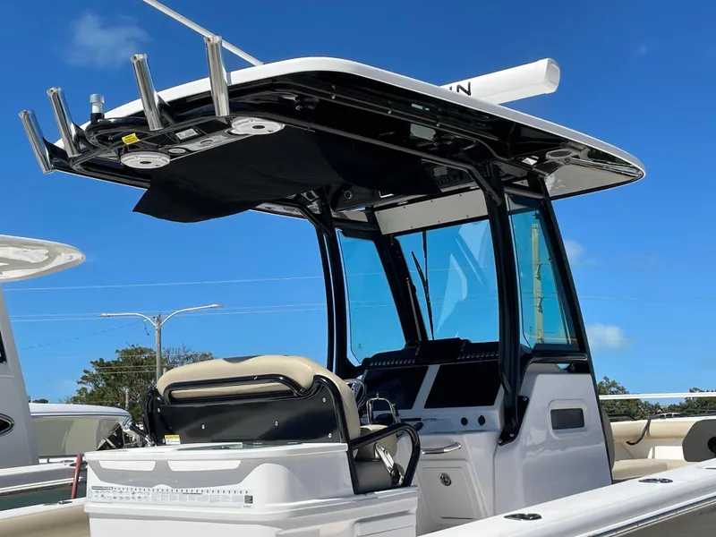 Slide: The Image of 2020 Everglades 273 Center Console boat with T-top and seating, under clear blue sky. - 32