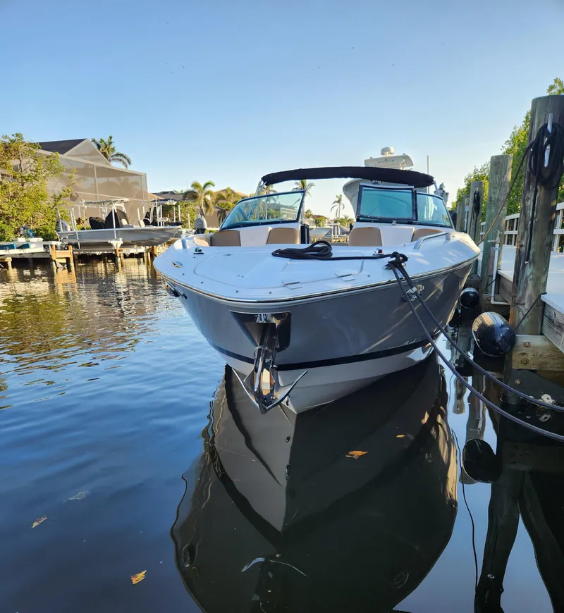 Slide: The Image of 2015 Four Winns Horizon H290 boat docked in a serene waterfront setting. - 0